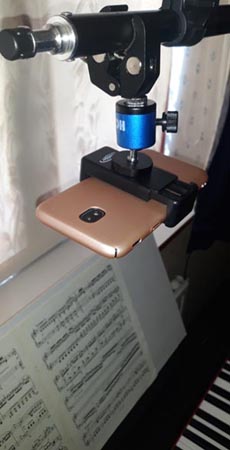 mobile phone mounted over a piano keyboard